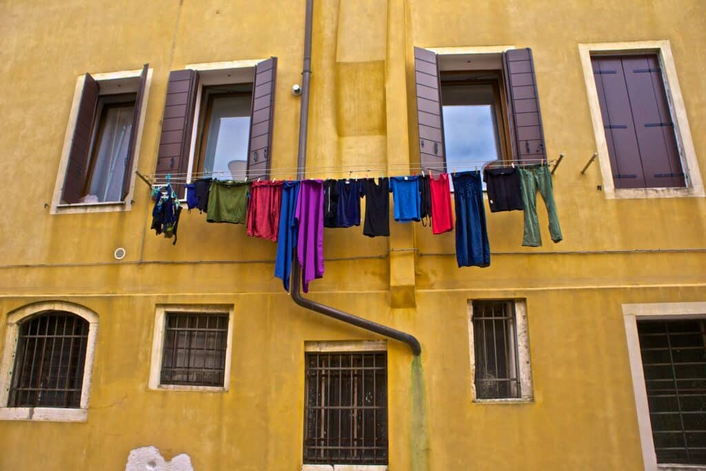 Clothes hanging up to dry on a washing line on the outer wall of a yellow building in Venice's Jewish Ghetto.