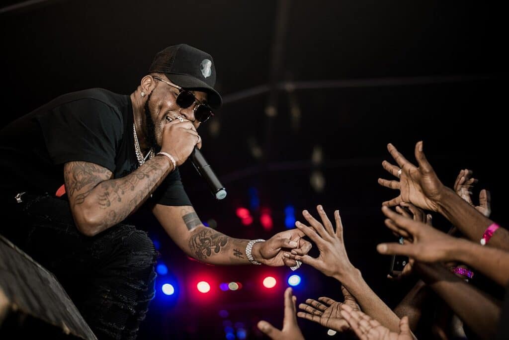 David Adedeji Adeleke (Davido), one of the most famous Nigerians, reaching out to hands in the crowd while performing.