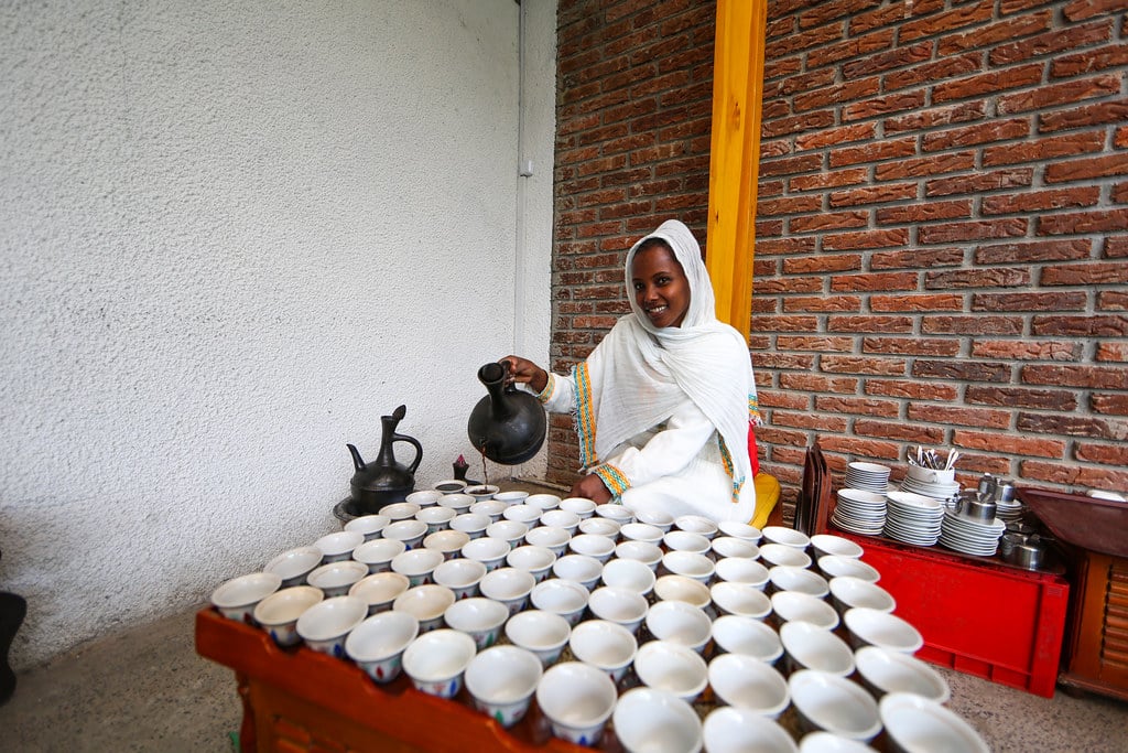 Picture of a lady serving Ethiopian traditional coffee, depicting Ethiopia as one of the best countries for coffee lovers.