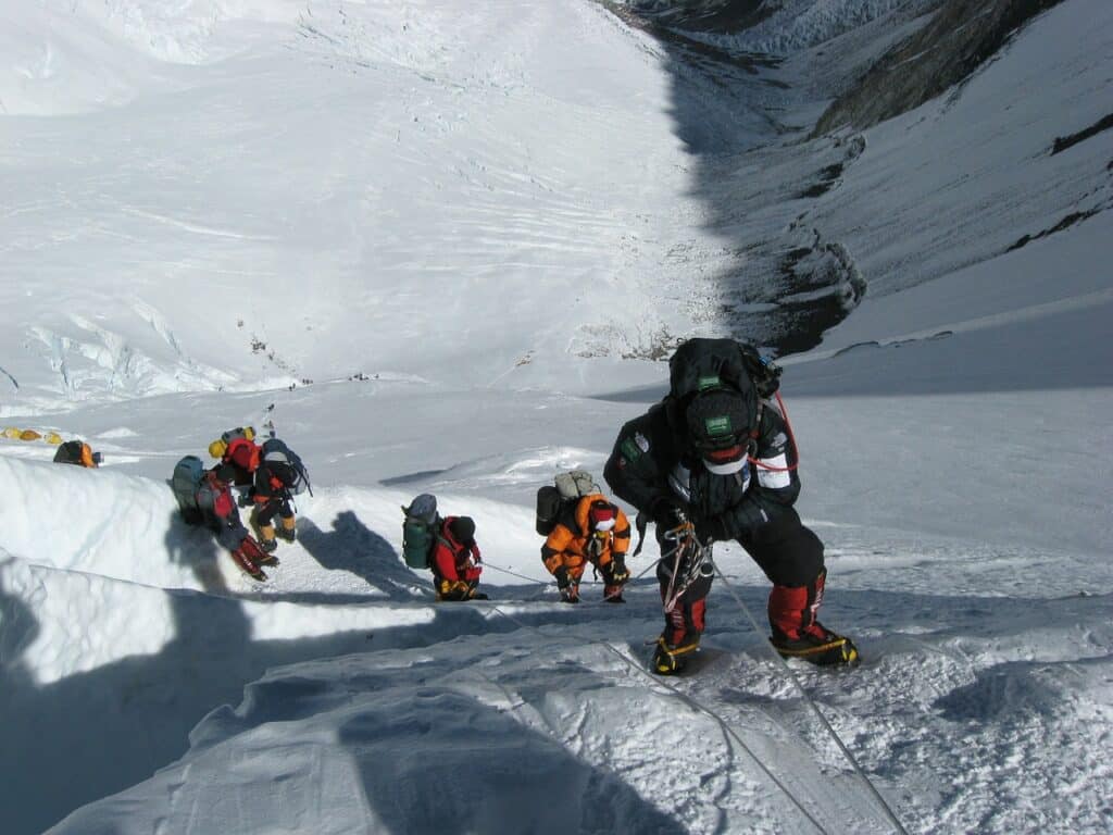 Picture of people climbing Mount Everest. Used to explain the overcrowded reality of climbing Everest.