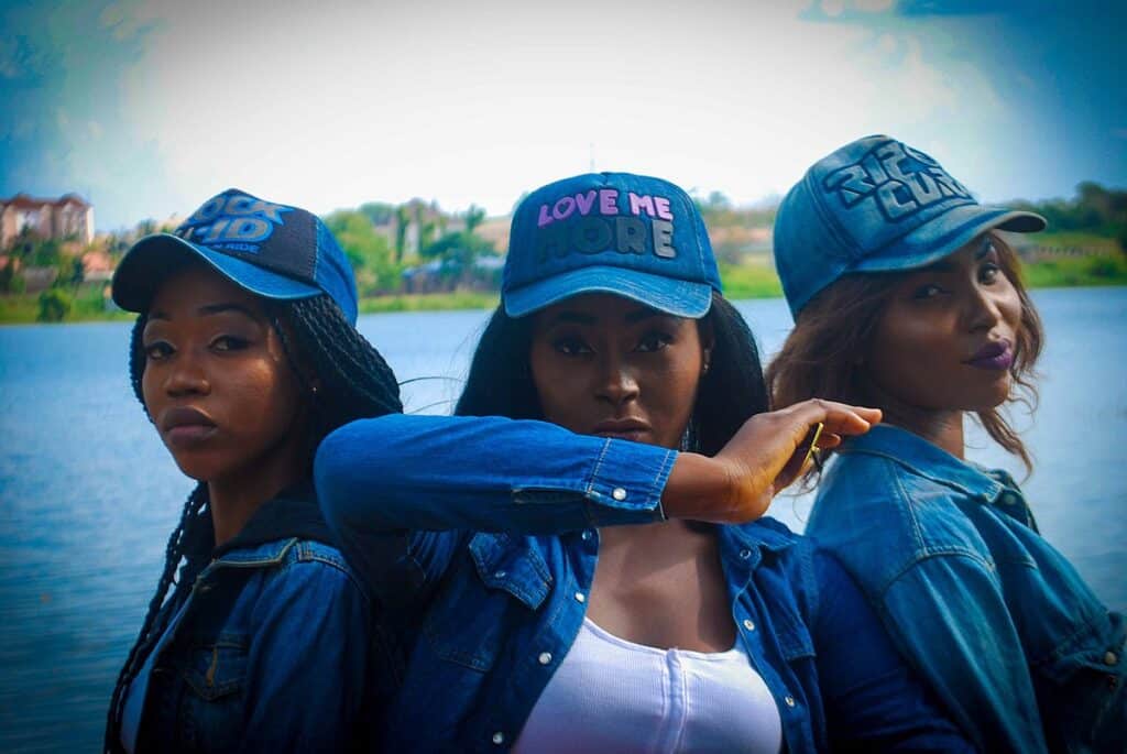 Three Nigerian fashion models pose near a river. Nigerian fashion is another reason Nigeria should be your next adventure.