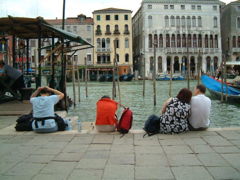 Picture of travellers sitting and resting close to a pool.