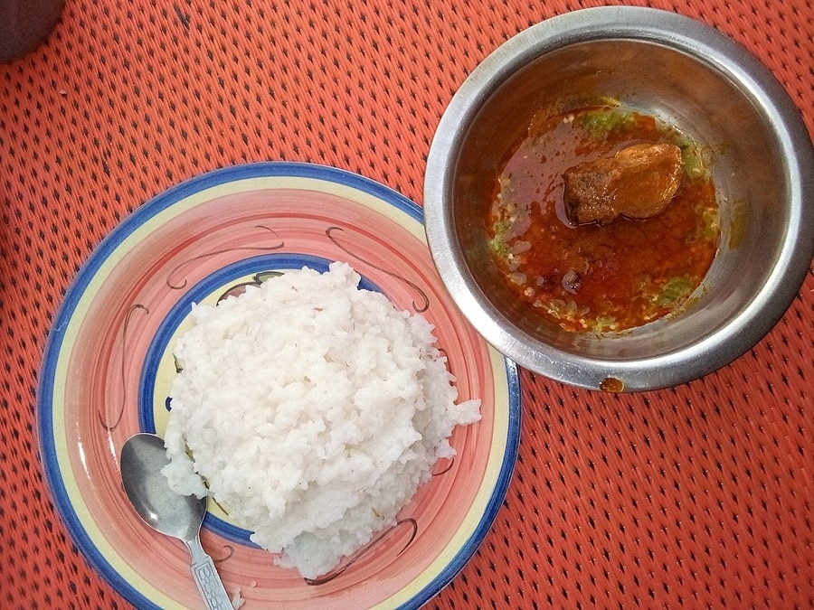 A porcelain bowl of tuwo shinkafa (left) and a steel bowl of okro soup (right)