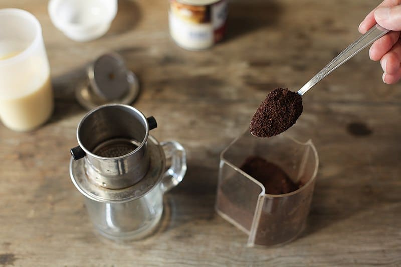 Picture of hand scooping Vietnamese coffee.